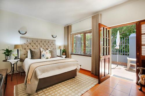 a bedroom with a large bed and a balcony at The River Guestroom in Krugersdorp