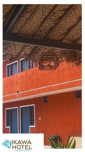 an orange building with a wooden roof and windows at Hotel Ikawa in La Loma
