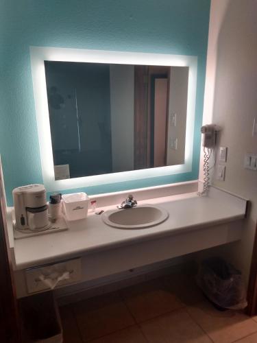 a bathroom with a sink and a large mirror at Howard Johnson by Wyndham Roseburg in Roseburg
