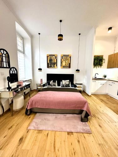 a bedroom with a large bed and a wooden floor at Apartamenty Dream Place in Toruń