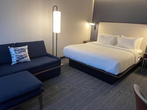 a hotel room with a bed and a couch at Courtyard Montreal Midtown in Montréal