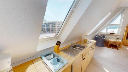 eine Küche mit einem Waschbecken und einigen Fenstern in der Unterkunft GAST-ZEIT Kliff 3 in Grömitz