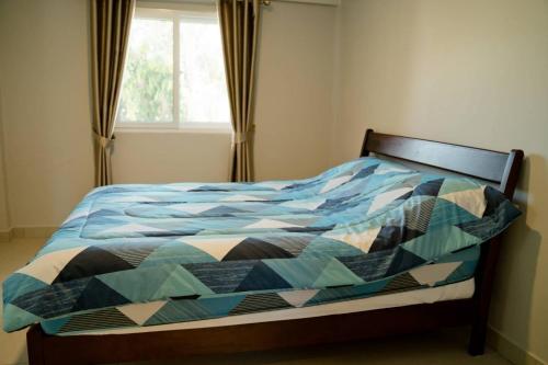 Ban Huai Lam Choeng Krai的住宿－บ้านช้าง ด่านขุนทด(Ban Chang Dankhunthod)，卧室内一张带五颜六色棉被的床