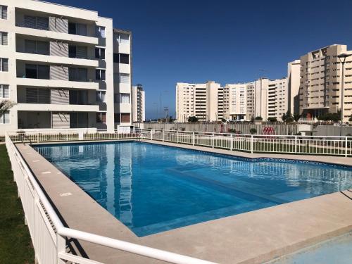 a large swimming pool in front of some buildings at Hermoso Jardines del Pacifico in La Serena