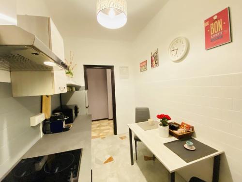 a kitchen with a table and a clock on the wall at Milano Relax Room in Brugherio