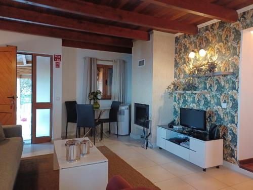 a living room with a television and a table with chairs at Fantatic Holiday House in Ponta Delgada