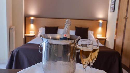 two glasses of champagne in a bucket next to a bed at Annapurna M&P in Ordino