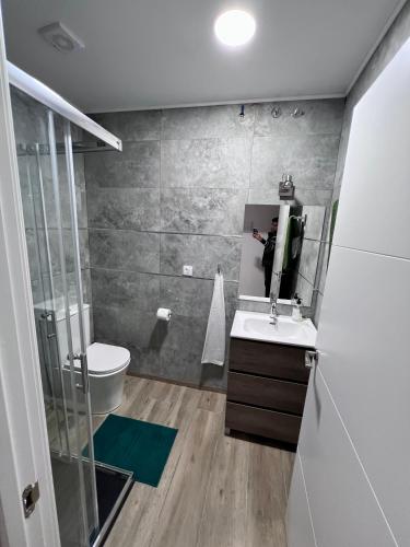 a bathroom with a toilet and a sink and a mirror at Soñar en la Plaza Cervantes 2 in Alcalá de Henares