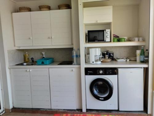 cocina con lavadora y microondas en Sainte-Anne en Sainte-Anne