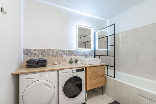 a bathroom with a washing machine and a sink at Appartement Cosy très proche Disney in Coupvray