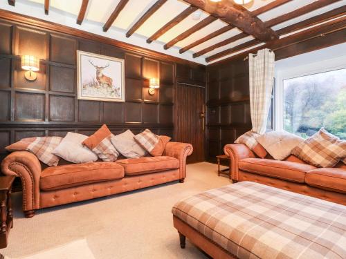 uma sala de estar com sofás de couro e uma janela em Grey Walls em Penrith