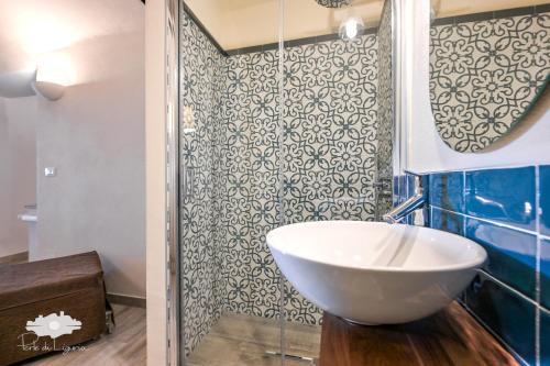ein Badezimmer mit einem weißen Waschbecken und einer Dusche in der Unterkunft PIEDS DANS L'EAU in Bogliasco