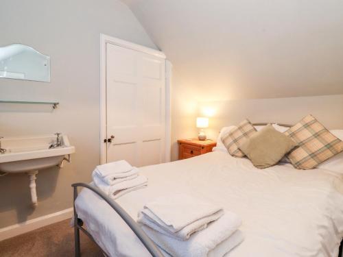 a bedroom with a white bed with towels on it at Grey Walls in Penrith