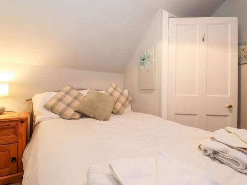 a bedroom with a white bed with pillows on it at Grey Walls in Penrith