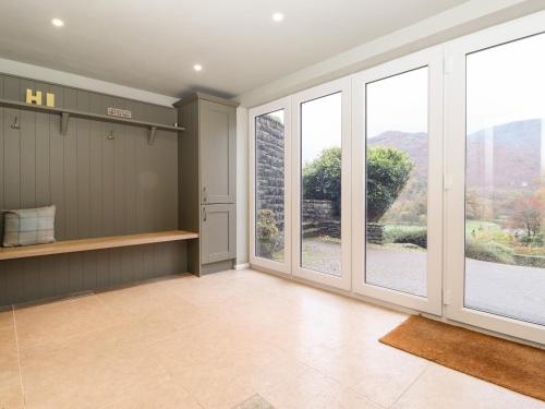 a large room with large windows and a kitchen with a view at Grey Walls in Penrith