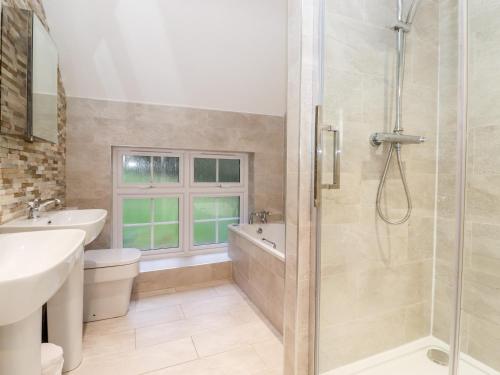 uma casa de banho com um chuveiro, um WC e um lavatório. em Grey Walls em Penrith