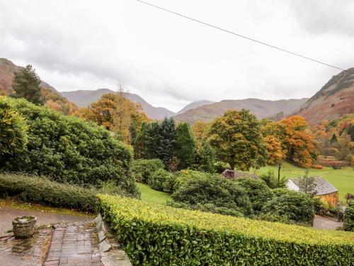 a garden with a hedge and mountains in the background at Grey Walls in Penrith