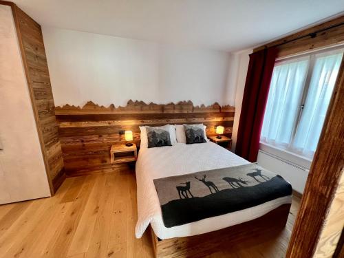 1 dormitorio con 1 cama con pared de madera en Casa Salvaterra Suite 44, en Pinzolo