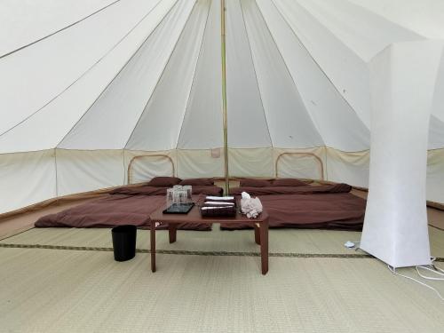 Una cama en una tienda con una mesa. en Glamchette Okayama -Glamping & Auto Camp- - Vacation STAY 19593v, en Mimasaka