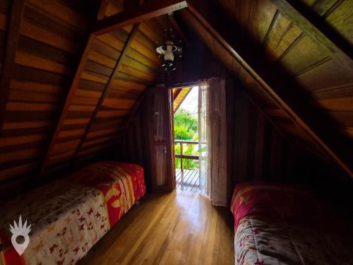Duas camas num quarto com uma janela grande em Chalé europeu com vista para natureza no interior em Indaiatuba
