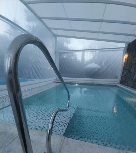 a swimming pool in a room with a window at Panacea Hotel in Villa General Belgrano