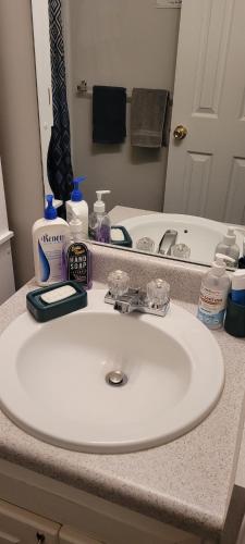 a bathroom counter with a white sink and a mirror at Central Pointe Pad in Riverdale