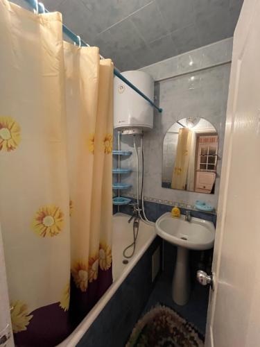 a bathroom with a sink and a shower curtain at 2-на квартира вул. Михайла Донця 5, поруч НАУ, КПІ, клініка Шалімова, метро Шулявська -15 хв in Kyiv