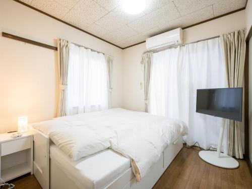 a bedroom with a bed and a flat screen tv at maison elegance - Vacation STAY 15798 in Tokyo