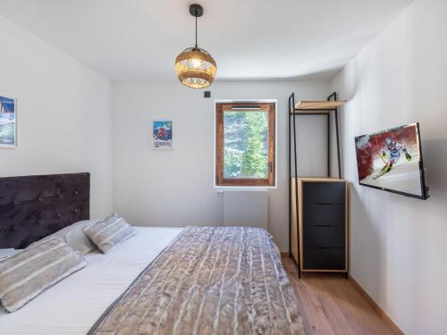 une chambre avec un grand lit et une fenêtre dans l'établissement Appartement récent, proche des pistes avec balcon et parking à Courchevel - FR-1-563-138, à Courchevel