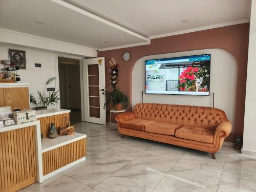 ein Wohnzimmer mit einem Sofa und einem Flachbild-TV in der Unterkunft Park Hotel Rooms & Apart in Antalya