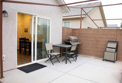 a patio with a table and chairs and a grill at ZC2 Home Base for Zion With Two Masters in La Verkin