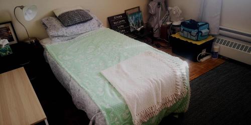 1 dormitorio con 1 cama con manta verde y blanca en Penthouse on the Lake, en Burlington