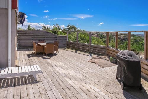 a wooden deck with a table and chairs on it at Seafront with Terrific View by AJF Dream Living in Fjällbacka