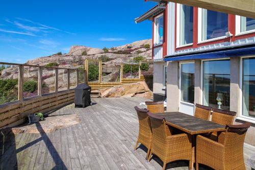 a wooden deck with a table and chairs on a house at Seafront with Terrific View by AJF Dream Living in Fjällbacka