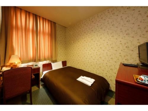 a hotel room with a bed and a desk at Zentsuji Grand Hotel - Vacation STAY 16629v in Zentsuji