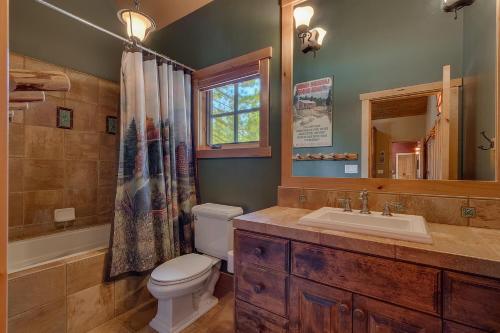 uma casa de banho com um WC, um lavatório e um espelho. em New Listing! West Shore Bliss - 4BR, Private Hot Tub em Tahoe City