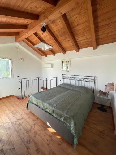 um quarto com uma cama grande num quarto com tectos em madeira em La casa dell'ulivo em Imperia