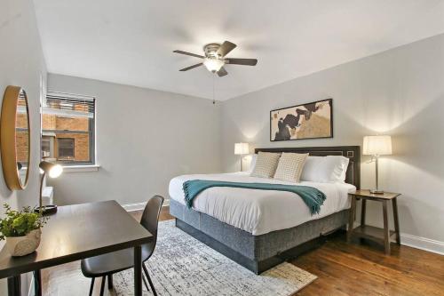 a bedroom with a bed and a table and a desk at 2BR Roomy & Stylish Apartment in Rogers Park - Sheridan N2 in Chicago