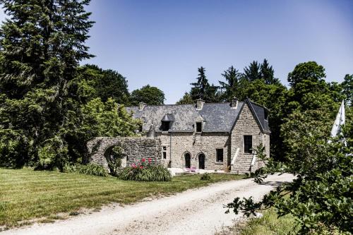 una vieja casa de piedra en un camino de tierra en Le Manoir de Menglieu, en Treffléan