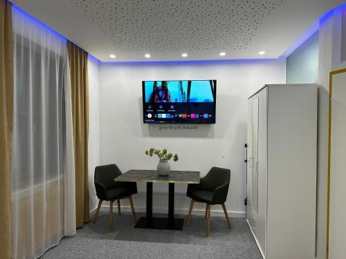 um quarto com uma mesa e uma televisão na parede em Modern Apartments Neuburg 1 - TOP NEU - 2 Zimmer, Komfort, Zentrum, Wi-Fi, Smart TV, Stellplatz, Küche em Neuburg an der Donau