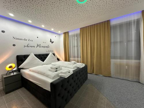 um quarto com uma cama com lençóis brancos e almofadas em Modern Apartments Neuburg 1 - TOP NEU - 2 Zimmer, Komfort, Zentrum, Wi-Fi, Smart TV, Stellplatz, Küche em Neuburg an der Donau