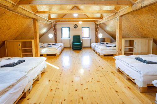 Habitación con 4 camas y suelo de madera. en Hostel Gabronka, en Bistrica ob Sotli