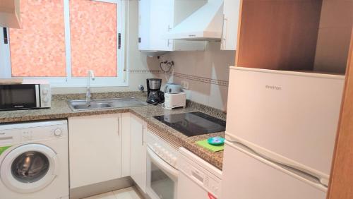 a small kitchen with a sink and a washer and dryer at Apartamentos varios con 2 dorm en Marina Dor , la playa de Amplaries 47 , vista lateral al mar in Oropesa del Mar