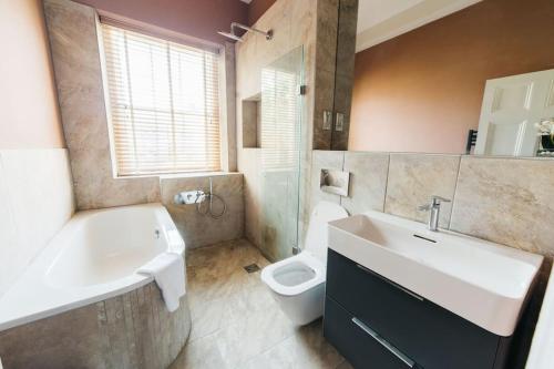 a bathroom with a sink and a tub and a toilet at Luxury, Central, Sun-Filled 3 Bed Haven in Bath in Bath