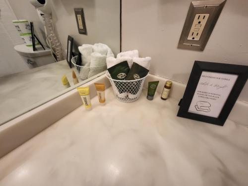 a bathroom counter with a sink with towels and a mirror at Cedar Lodge Condo with Lake Winnipesaukee Views; close to Weirs Beach!! in Laconia