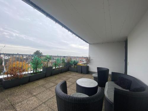 a balcony with chairs and tables on a building at Wohnung mit Dachterrasse in Mörfelden-Walldorf