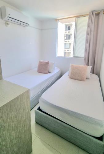 a bedroom with two beds and a window at Amplio y Residencial piso 9 in Cartagena de Indias