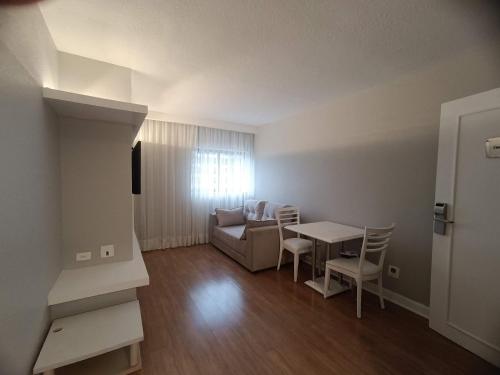 a living room with a couch and a table and chairs at Apto-Flat Excelente Localização Centro-Batel - Somente Familiares in Curitiba