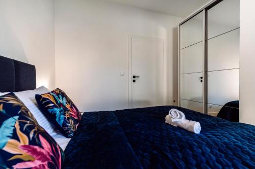 a bedroom with a bed with a blue comforter at Apartamenty Belni Hel Edyta i Maciej Wolak in Hel