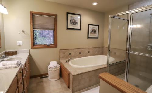 a bathroom with a tub and a glass shower at LakePlace Bed & Breakfast 